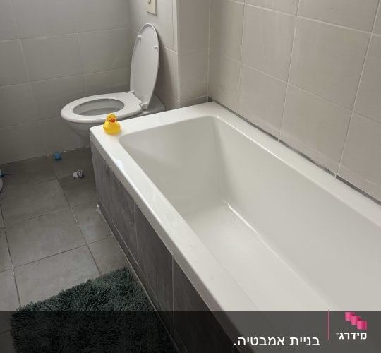 אמבטיה חדשה עם אריחים לבנים ושירותים